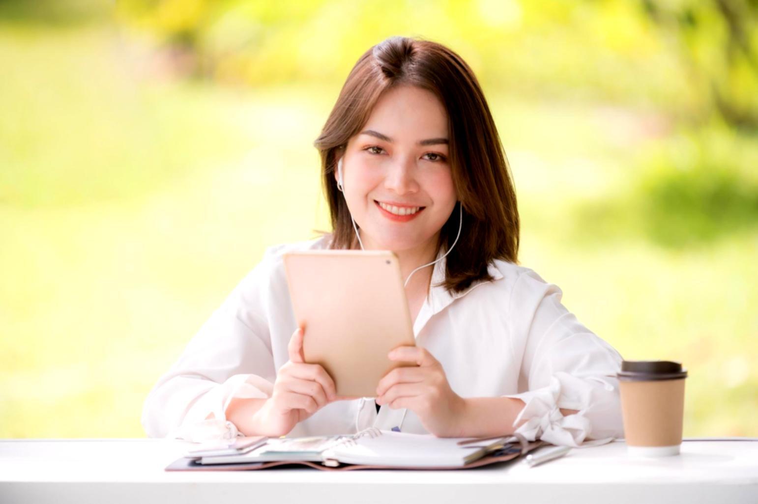 Manos escribiendo notas financieras en cuaderno con gráficos
